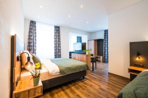 a hotel room with a bed and a television at Hotel Wilder Mann in Steinach am Brenner