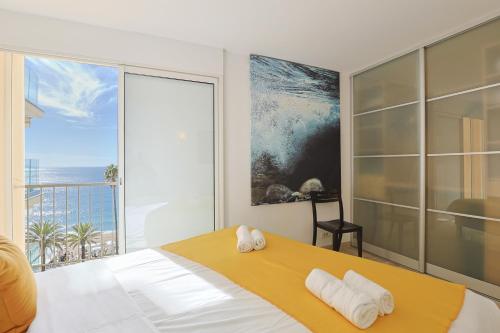 a bedroom with a bed with a view of the ocean at Mer du Sud 4 YourHostHelper in Cannes