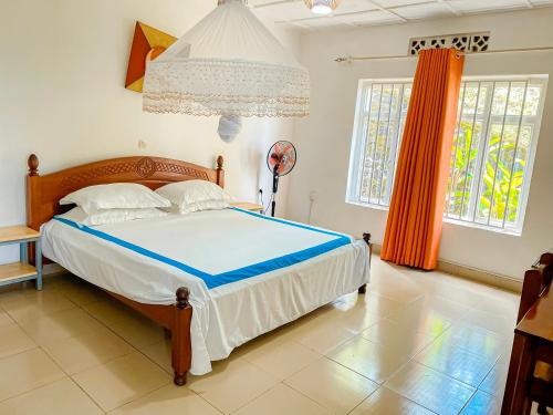 a bedroom with a bed and two windows at Musanto Hotel in Gisenyi