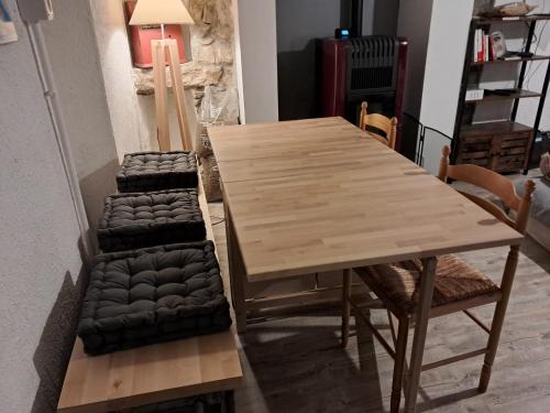 a wooden table and chairs in a living room at La Modestine in Lanuéjols