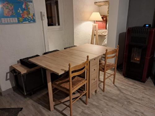 a wooden table and two chairs in a room at La Modestine in Lanuéjols