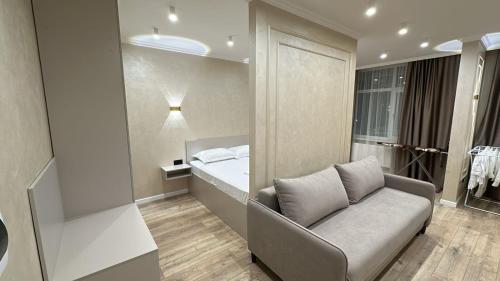 a living room with a couch and a bed at Мегаполис in Astana