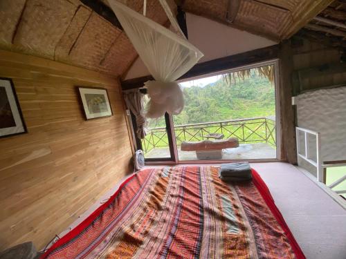 a room with a bed with a large window at Pam Hill in Bản Pha Xum