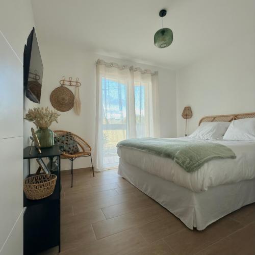 a white bedroom with a bed and a window at Villa Saint Mart-Tout Inclus-Plage à 7 min à pied in Saint Martin de Brehal