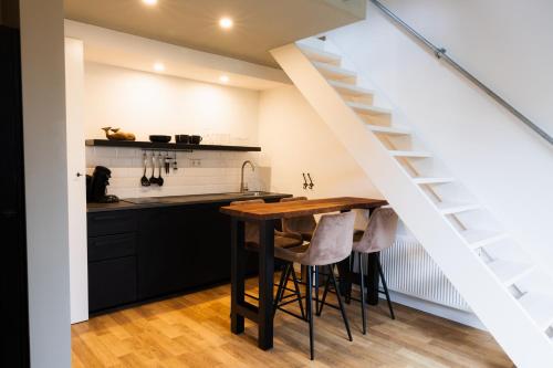 a kitchen with a wooden table and a staircase at Yart in Scharendijke