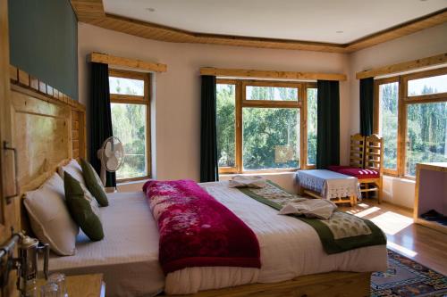 a bedroom with a large bed in a room with windows at Semba retreat in Hundar