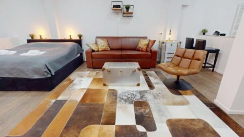 a bedroom with a bed and a couch and a chair at Wohnung mit Heimkino mitten in der Altstadt in Celle