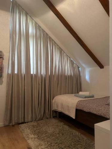 a bedroom with a bed and a window with curtains at Villa BELEVITA odmor u prirodi sa grijanim bazenom in Čepelovac