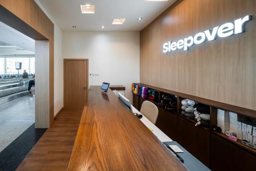 a store with a sign that reads sleepover on the wall at Sleepover Terminal 1, Concourse D - formerly sleep 'n fly in Dubai
