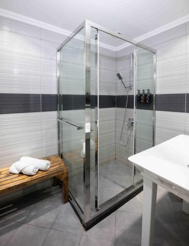 a glass shower with a bench in a bathroom at Sleepover Terminal 1, Concourse D - formerly sleep 'n fly in Dubai