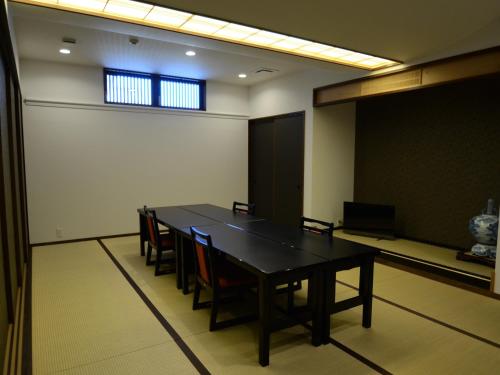 a conference room with a black table and chairs at umashiyado ryoutei minoshima in Kaino
