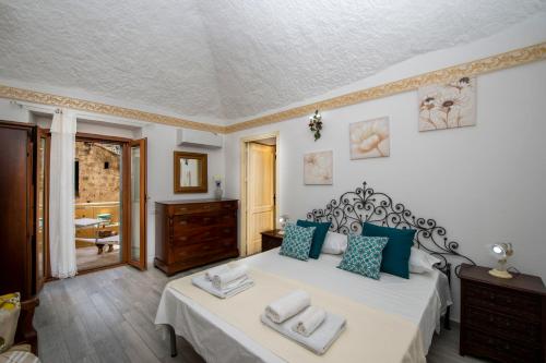 a bedroom with a large bed with blue pillows at Casa Sery in Positano