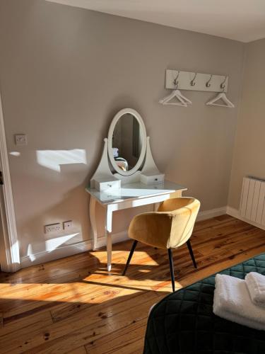a dressing table with a mirror and a chair at Kerry Holiday Homes at the Killarney Holiday Village in Killarney