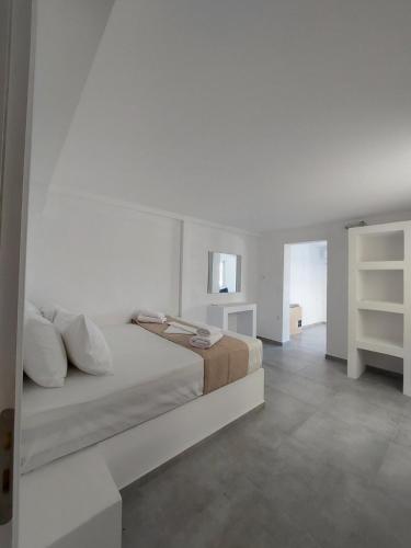 a white bedroom with a bed with white walls at Puerto Serifos in Livadi
