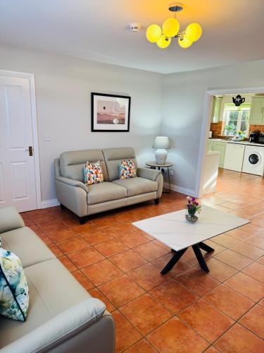 a living room with a couch and a table at Kerry Holiday Homes at the Killarney Holiday Village in Killarney