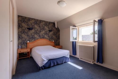a small bedroom with a bed and a window at Auberge de la Loire in Montjean-sur-Loire