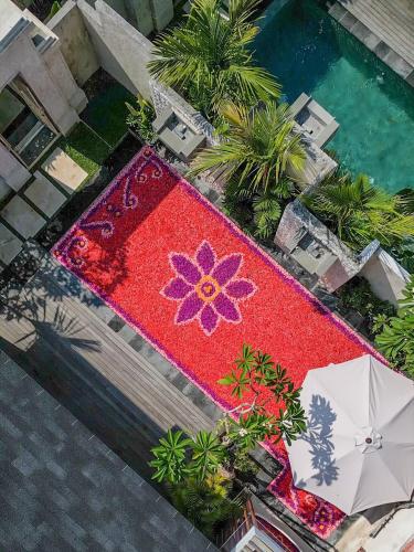 an overhead view of a red rug with a flower on it at The Arca Villas by GenuineHost in Sanur