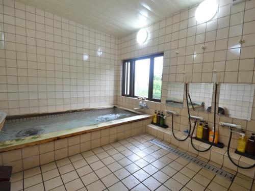 a bathroom with a large tub with a window at umashiyado ryoutei minoshima in Kaino