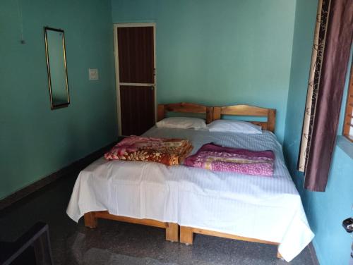 a bedroom with a large bed with a wooden headboard at Gubbikanta Homestay in Aralagodu