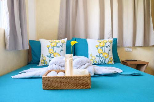 a bed with a basket with towels and a vase on it at Kalija in General Luna