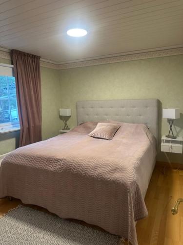 a bedroom with a bed and two lamps and a window at Privat strandvilla i vackra Geta in Geta