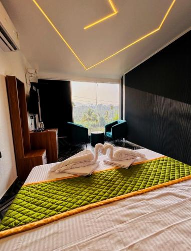a bedroom with a large bed with a green mattress at West wind Resort in Meppādi