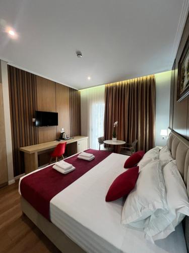 pokój hotelowy z dużym łóżkiem i czerwonymi poduszkami w obiekcie CLASS Hotel w mieście Ksamil