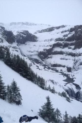 a snow covered mountain with trees and a river at Skjólsteinar in Grundarfjordur
