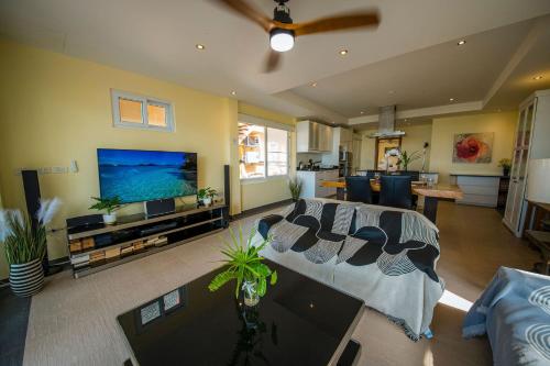 a living room with a couch and a tv at Tankini Beachfront Villa in Ban Khlong Son