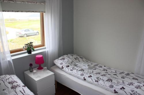 um pequeno quarto com uma cama e uma janela em Skjólsteinar em Grundarfjordur