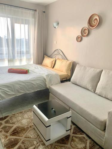 a living room with a couch and a bed at Cozy Studio in Nairobi's Prime Location in Nairobi