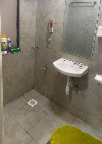 a bathroom with a sink and a mirror at Cozy Studio in Nairobi's Prime Location in Nairobi