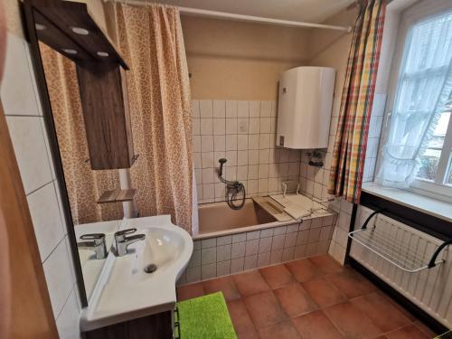 a bathroom with a sink and a bath tub at Grenzstübchen in Hötensleben