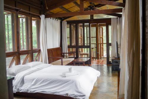 a bedroom with a bed and a living room with windows at Alun Hostel in San Felipe