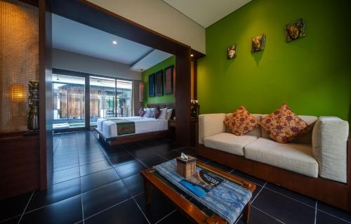 a room with a bed and a couch and a table at Gaing Mas Jimbaran Villas by Gaing Mas Group in Jimbaran