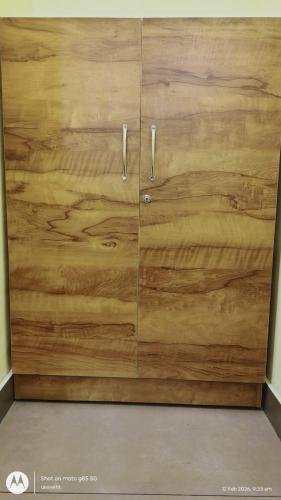 a wooden cabinet with two doors in a room at The Haira Retreat in Kappil
