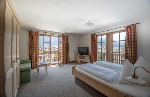 a hotel room with a bed and a balcony at Hotel Vermoi in Laces
