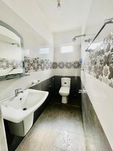 a bathroom with a white sink and a toilet at Aamy Luxury Villa in Galle