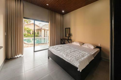 a bedroom with a large bed and a pool at Homestay coffee Hoàng Nhạn in Mỹ Hòa (1)