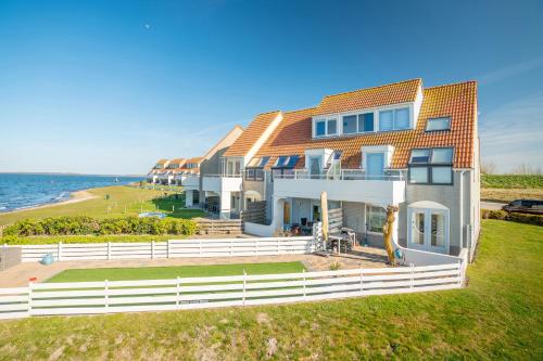 a large building with the ocean in the background at Summio Parc Port Greve in Brouwershaven