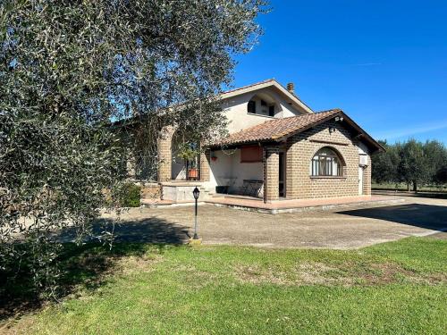 a large brick house with a tree in front of it at La Casa di Ori in Castel SantʼElia