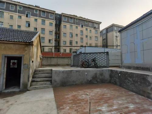 a bike parked next to a building with buildings at 天天绘住 in Xianzong