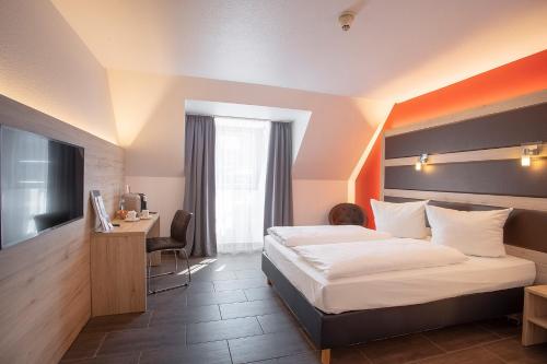 a hotel room with a bed and a desk at ACHAT Hotel Heppenheim in Heppenheim an der Bergstrasse