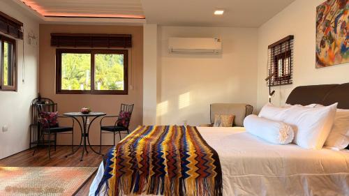 a bedroom with a bed and a table and a window at This Great Place in Don Sak