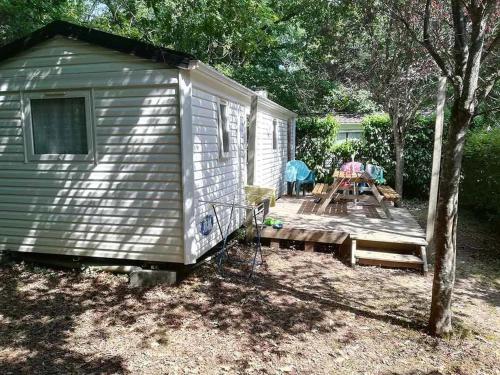a small shed with a table and a picnic table at Camping 3 étoiles - Piscine - ccbfeb0 in Mayrac