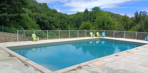 a swimming pool with chairs and a fence around it at Camping 3 étoiles - Piscine - ccbfeb0 in Mayrac