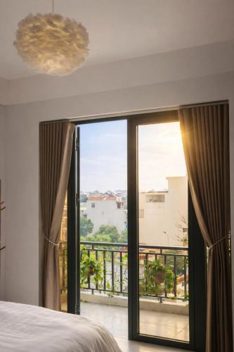 a bedroom with a large glass door leading to a balcony at Mèn Mén Home in Phú Thọ