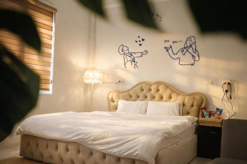 a bedroom with a bed with drawings on the wall at Mèn Mén Home in Phú Thọ