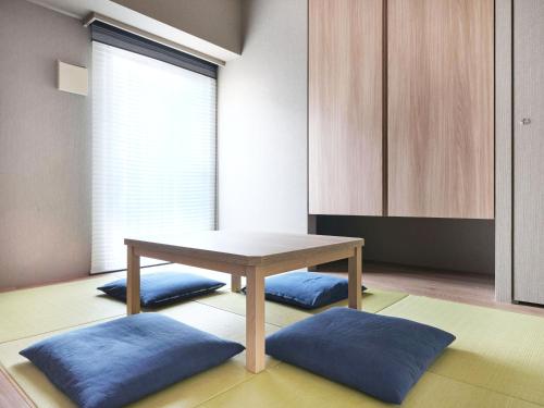 a dining room with a table and blue cushions at MONday Apart Premium AKIHABARA in Tokyo