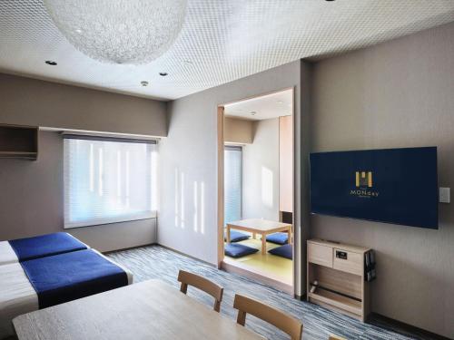 a room with a bed and a table and a mirror at MONday Apart Premium AKIHABARA in Tokyo